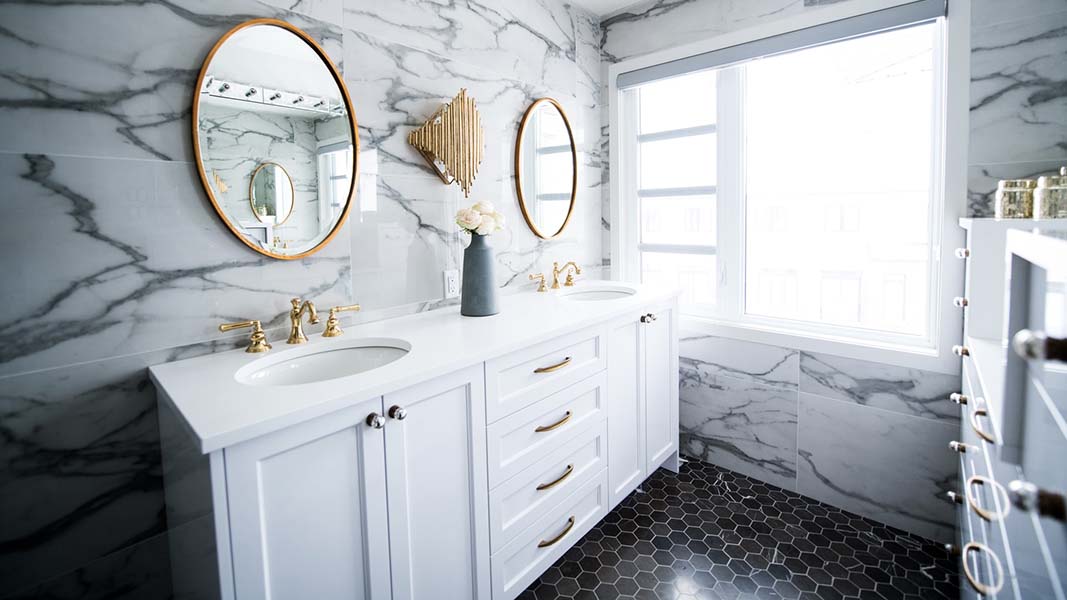 luxury bathroom with marble tile and white vanity